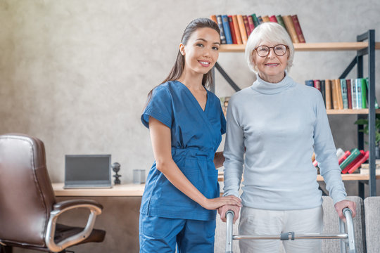 Portrait of senior woman and supporting nurse at home