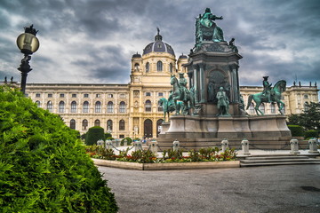 Natural History Museum in Vienna with green hedge and monument in cloudy background and street lamp