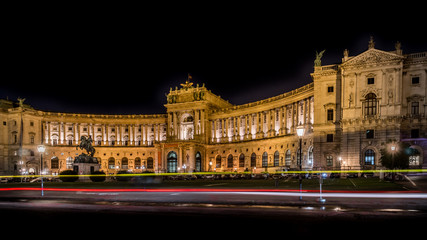 Fototapeta na wymiar Illuminated Heldenplatz (Heroes Sqaure)at night with red yellow color light rails