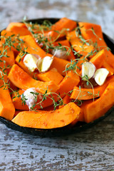 Raw pumpkin slices in a pan before baking. Cooking pumpkins. Autumn food. Keto friendly. Selective focus.