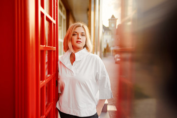 Outdoor portrait of happy young woman walking by city street.