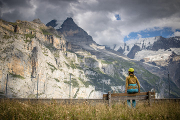 Fototapeta na wymiar Pretty, female climber on a via ferrata - climbing on a rock in Swiss Alps