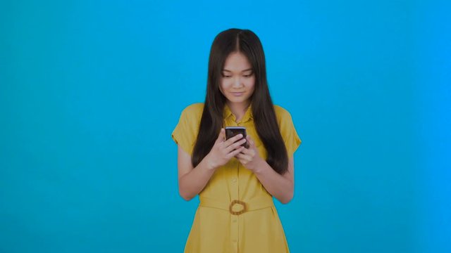 korean,asian woman reads news carefully isolated on dark blue background,girl hol phone,copy space 4K
