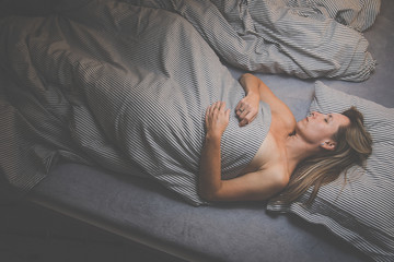 Pretty, middle-aged woman sleeping in her bed at home, having a good night rest in a comfortable bed