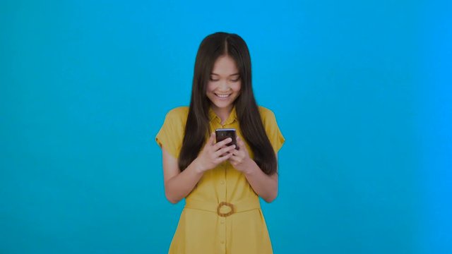 korean,asian woman reads news carefully isolated on dark blue background,girl hol phone,copy space 4K