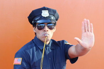 Policeman blowing whistle and showing stop hand gesture