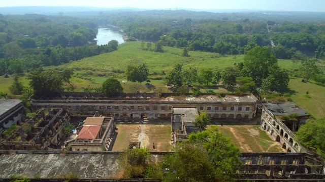 Aerial footage bird view of Van Den Bosch fort in Ngawi City, Java, Indonesia with green forest and riverside at background