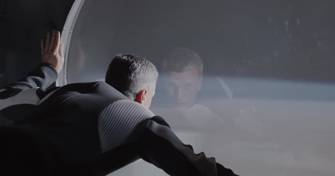 Astronaut looking out of spaceship window