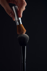 Fototapeta premium two powderbrush opposite each other on black background