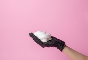 The stylist's hand in a black glove holds a hairbrush. hair care concept.