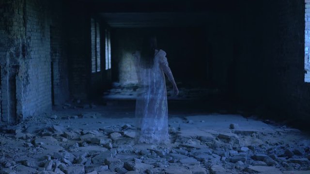 Female ghost walking and disappearing in old abandoned building, spirit of past