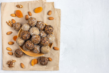 Homemade energy balls with dried apricots, raisins, dates, prunes, walnuts, almonds and coconut. Healthy sweet food. Copy space. Flat lay, top view