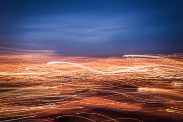 Lightpainting from intentional camera movement in the window showing night city lights