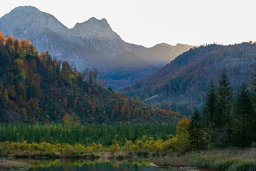 Fototapeta na wymiar Berge und Wälder am Almsee in Oberösterreich bei Sonnenuntergang im Herbst
