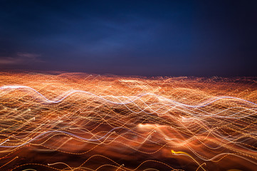 Lightpainting from intentional camera movement in the window showing night city lights