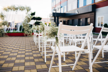 Place for wedding ceremony in white color , Decor Studio. white wooden chairs