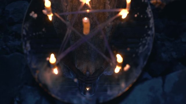 Mysterious pentagram on ritual mirror, reflection of occult magician with candle