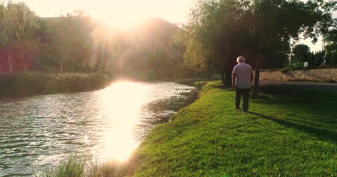 anciano paseando junto a r&iacute;o