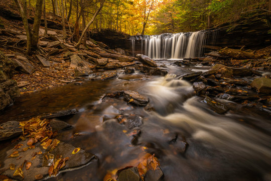 Autumn waterfall scenery with fallen leaves and beautiful fall colors at Ricketts Glen Park in Pennsylvania