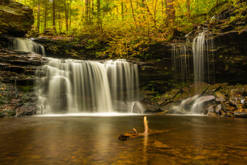 Autumn waterfall scenery with fallen leaves and beautiful fall colors at Ricketts Glen Park in Pennsylvania