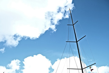 Black carbon mast or a racing sailboat with a Spanish visitor flag under spreader.