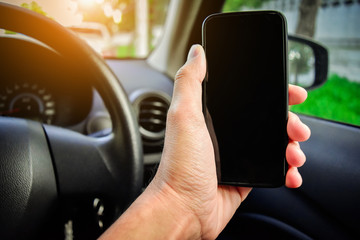Hand holding smart phone in car