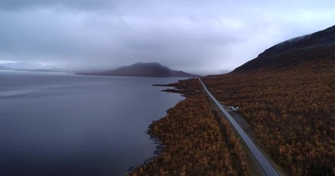 Truck on a arctic road, Aerial, descending, drone shot, revealing a lorry on e8 route, on a moody and rainy, autumn evening, in Enontekio, Kilpisjarvi, Suomi