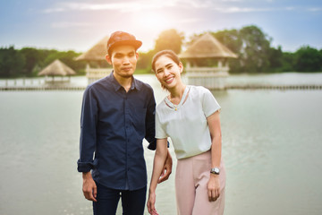 Fototapeta premium Asian young couple happy time in garden sunset background, couple cute and lovely