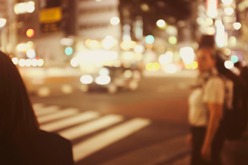 People walking at footpath in night time with light bokeh.Crowded street in Japan, blurred...