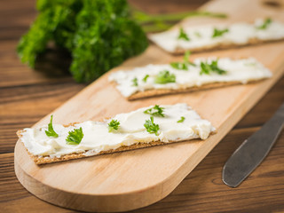 Three toasted toast with cream cheese on a chopping Board. Vegetarian snack.