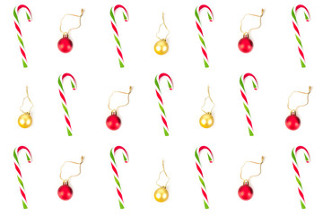 Minimal flat lay design of elements such as red and gold decoration ball and red and green striped sweet candy cane, for Christmas season on white background.