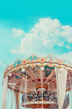 Retro pastel colorful Children's merry-go-round at the amusement park in the blue sky  and fluffy cloud background like in the heaven.