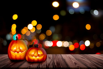 Halloween backdrop with the old grunge plank wood board with Jack-o-lantern and bokeh blur on the mystery dark background.