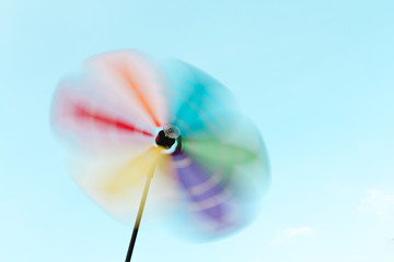Colorful pastel movement pinwheel in the blue sky background at the park during summer season feels happy and good.