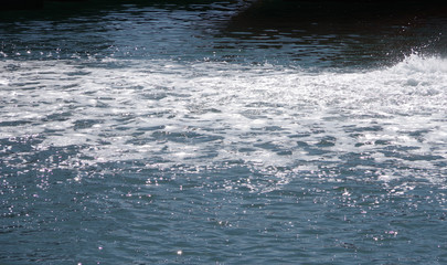 Close-up sectional full frame view of vividly splashed up rippled water in a harbor