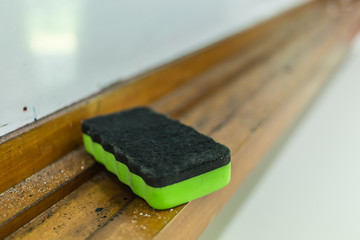 plastic green color whiteboard eraser closeup detail view