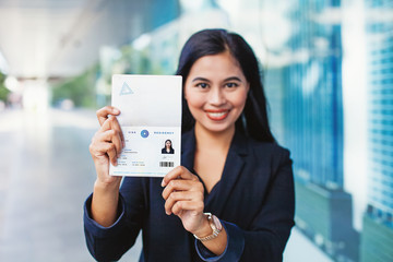 Asian woman showing valid visa and work permit in her passport