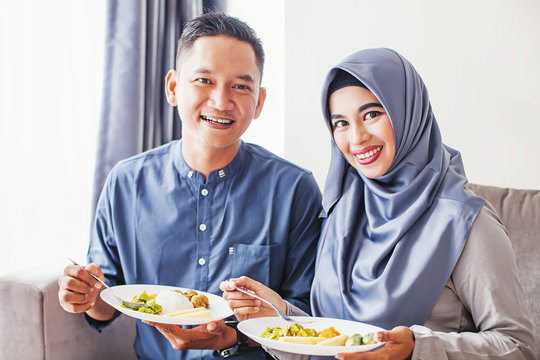 Beautiful southeast asian couple eating together (celebrating eid al fitr or eid al adha)
