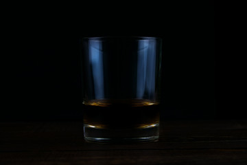 Glass of whiskey  on dark background.Whiskey on a wooden table