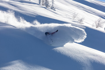 Extreme snowboarder has fun riding fresh powder snow off piste in white mountains. Pro rider...