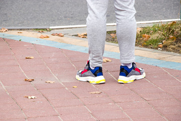 Fototapeta na wymiar The man at the bus stop. Waiting for transport. Bright sneakers.