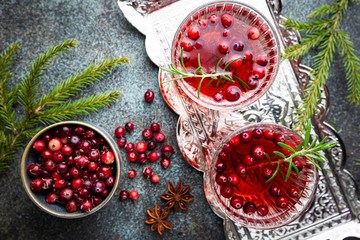 Fresh cranberry cocktail with rosemary in a glass on gray background, top view