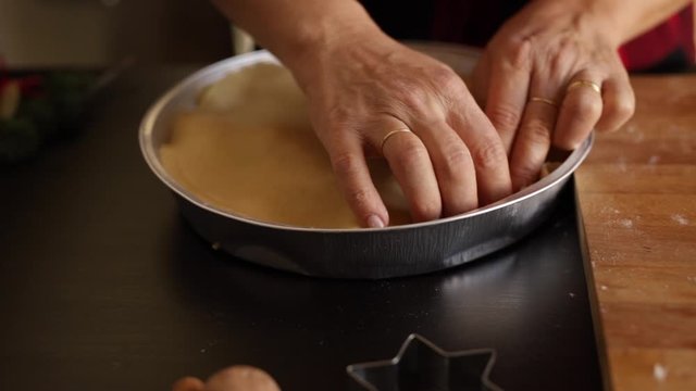Mani della donna che prepara una torta di mele in un vassoio. Classiche torte dolci per le vacanze