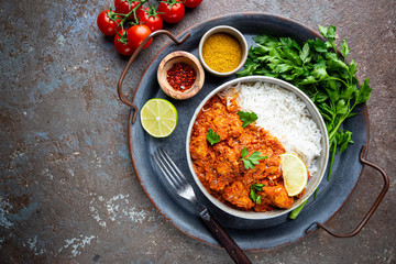 Chicken meat with tikka masala sauce, spicy curry food in a bowl with rice and seasonings, top view