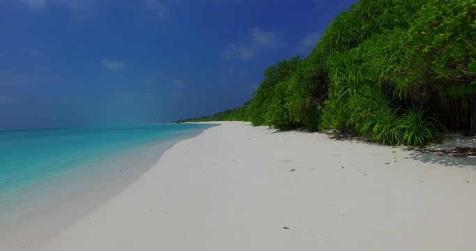 Perfect white sandy beach, small turquoise waves and vegetation. Paradise, Maldives. 