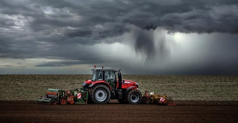Wandaufkleber schöne Landschaft mit einem Bauern, der vor dem Sturm seine Felder pflügt © Image'in