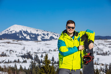 Fototapeta na wymiar man in sunglasses holding snowboard
