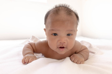 Newborn baby lay prone Was playing on the white mattress, refreshing, in a good mood During...