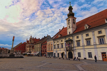 Fototapeta na wymiar Maribor, Slovenia-September 23, 2019: Stunning landscape view of The Rotovz Town Hall Square. Medieval Plague Column and ancient colorful building at the background. Maribor, Lower Styria, Slovenia