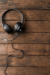Obraz na płótnie Canvas Headphones on wooden background. Call center concept